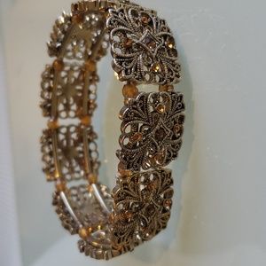 Monet gold tone stretch bracelet with yellow bead and topaz colored rhinestones